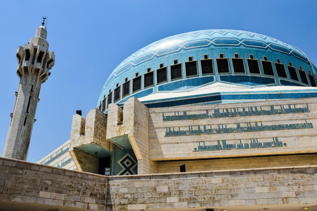 A stunning view of the King Abdullah I Mosque's blue dome and minaret in Amman, showcasing Islamic architecture.