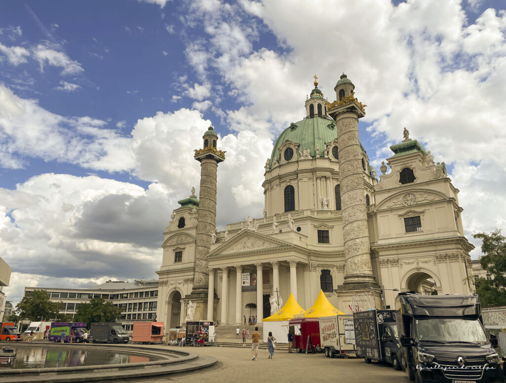 Iglesia de San Carlos Borromeo en Viena, fachada barroca con gran cúpula verde y columnas