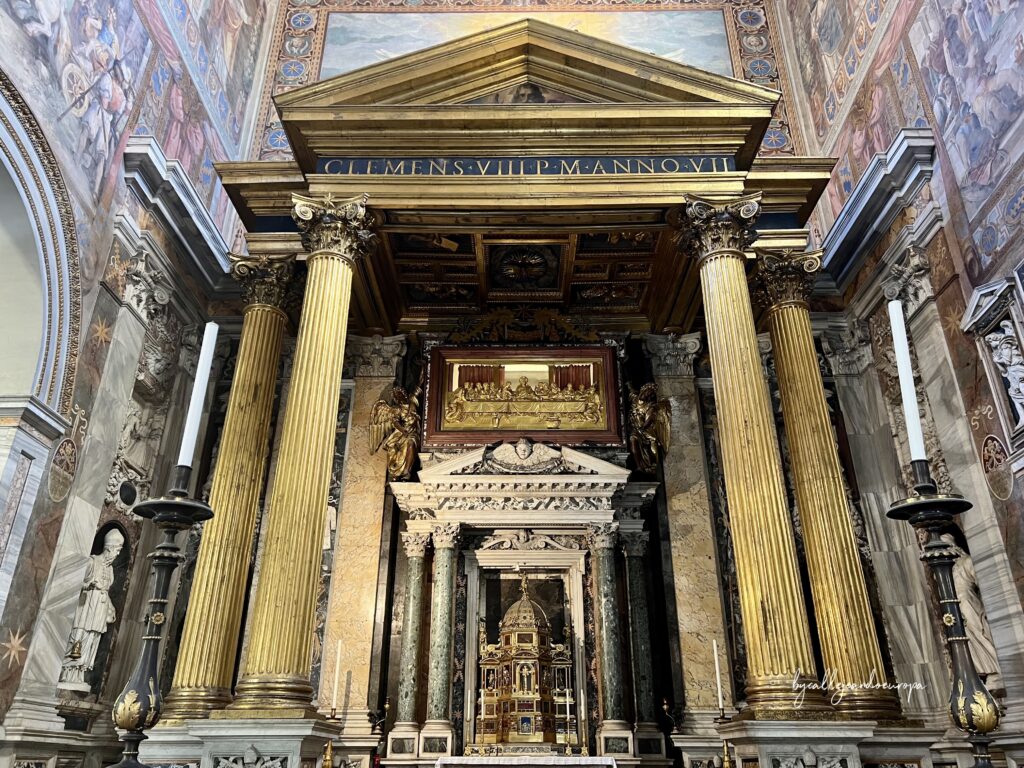 Altar del Santísimo Sacramento en la Archibasílica de San Juan de Letrán, Roma, con grandes columnas doradas, relieves de la Última Cena y frescos renacentistas