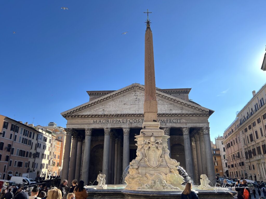 Fachada del Panteón de Agripa en Roma vista desde la Piazza della Rotonda con el obelisco de la fuente en primer plano.