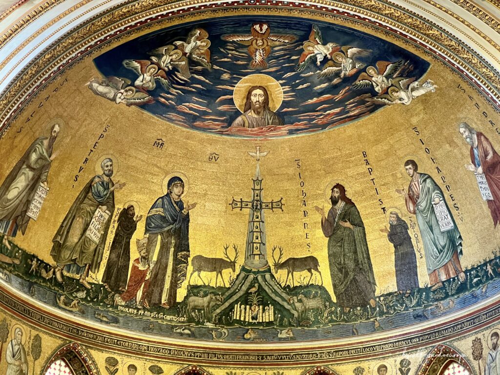Mosaico bizantino del ábside de San Juan de Letrán con la Santa Cruz central, ciervos bebiendo agua, figuras de santos sobre fondo dorado y el rostro de Cristo en el cielo