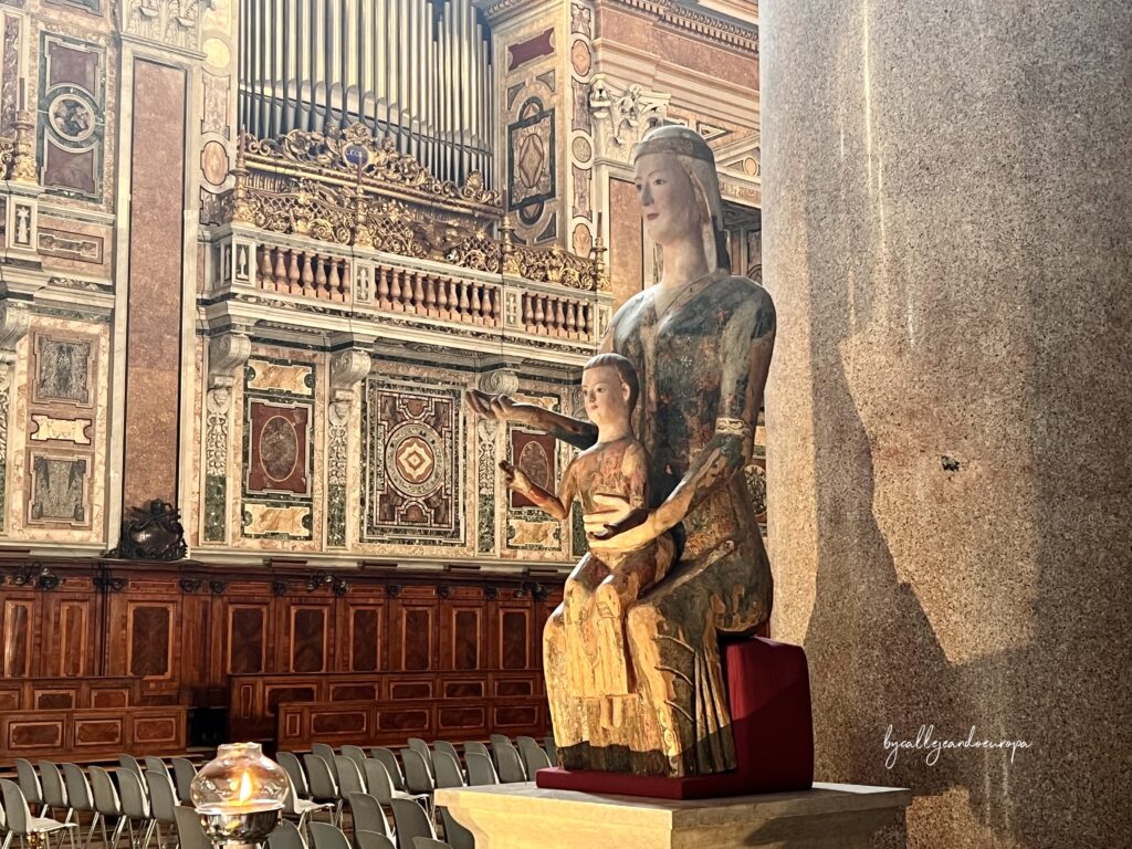 Escultura medieval de madera de la Virgen con el Niño en la Archibasílica de San Juan de Letrán, la Catedral Papal, con el órgano decorado y sillería de madera al fondo