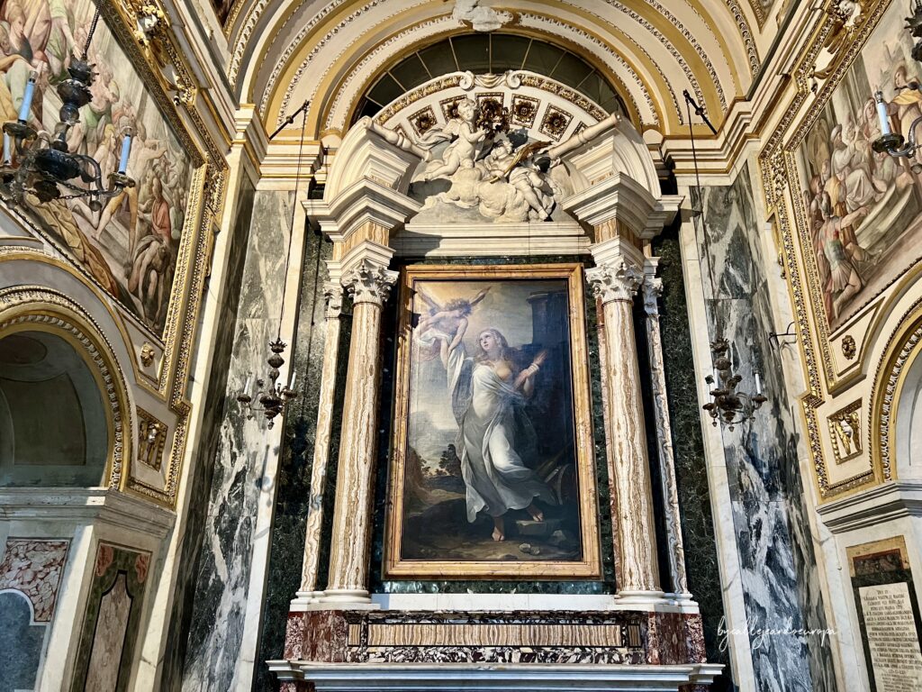 Altar barroco dedicado a Santa María Magdalena de Pazzi en la Iglesia de Santa Maria in Traspontina, con una gran pintura central y paredes revestidas de mármol veteado oscuro
