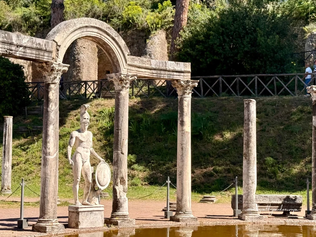 Estatua de mármol del emperador Adriano como Ares o el favorito Antínoo de pie bajo el gran arco del Canopo en Villa Adriana.