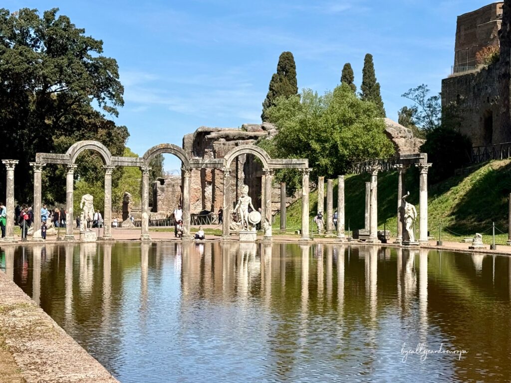 Columnas clásicas y estatuas reflejadas en el agua del Canopo en Villa Adriana