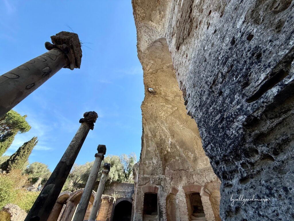 Vista desde el interior del Serapeo de Villa Adriana mostrando los restos de la bóveda de medio punto y columnas clásicas bajo el cielo azul.