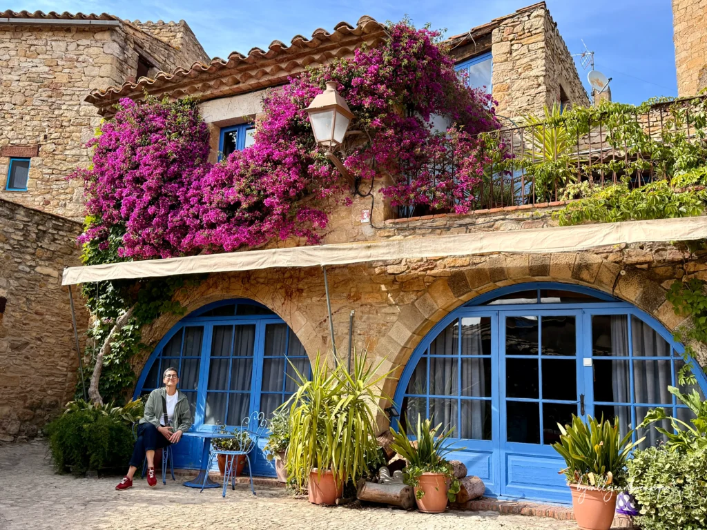 Rincón pintoresco en Peratallada, Girona, destacando la arquitectura de piedra y la flora típica de los pueblos del Baix Empordà